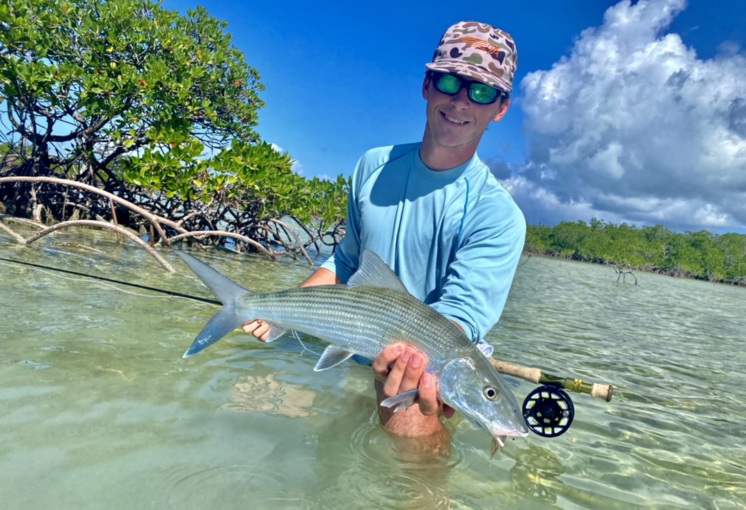 A man on the Florida Keys flats with a bonefish on fly.