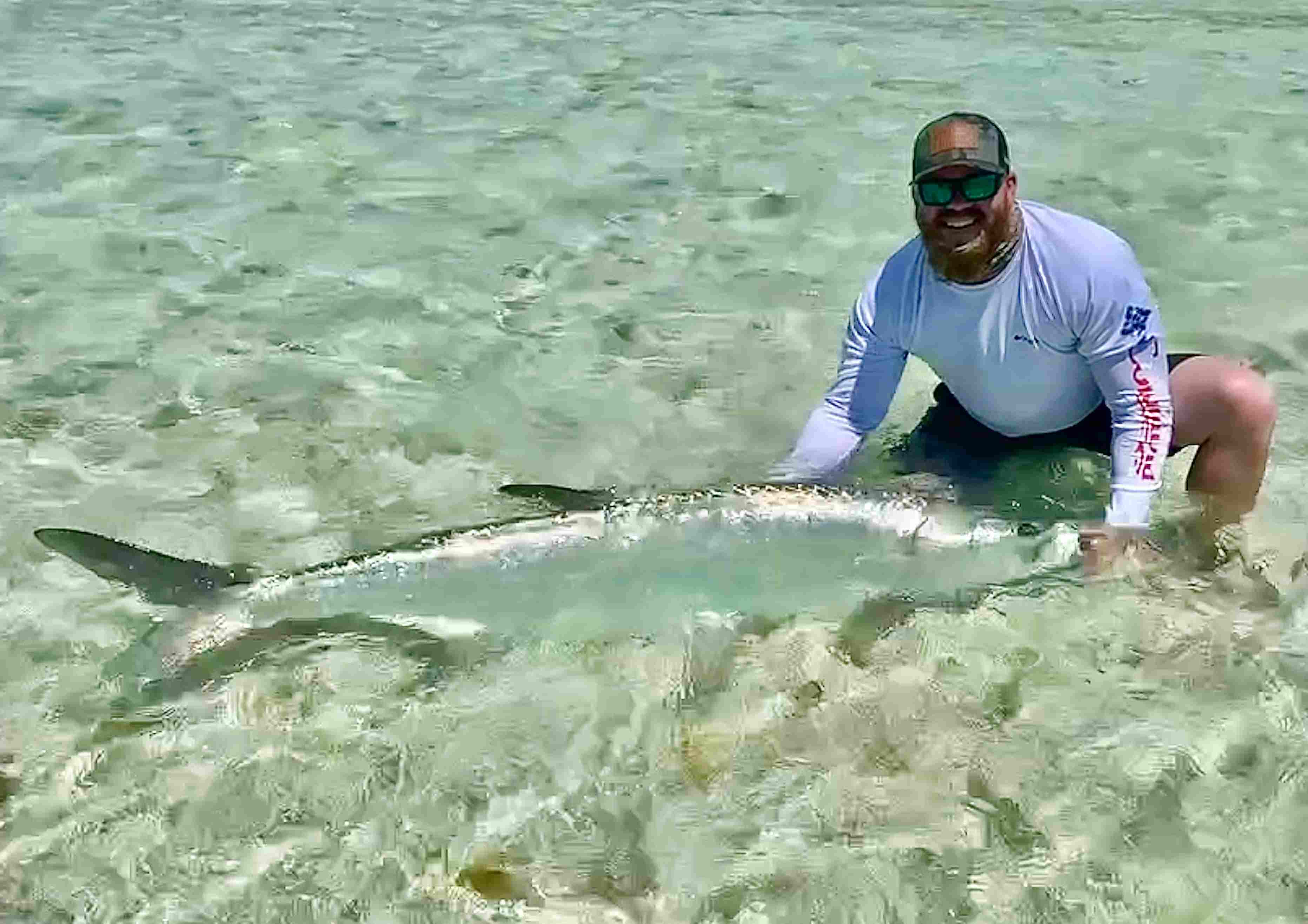 A florida keys tarpon fishing guide releasing a large tarpon.